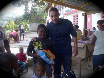 Nicolas Duvalier posing with kids at a toy distribution event for Christmas.